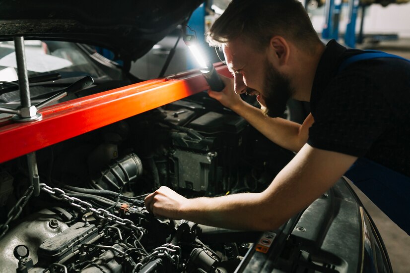 Auto mechanic inspecting car's engine