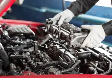 Engine-Diagnostics-and-Repair (Custom) The image shows a mechanic's hands working on the engine of a vehicle.
